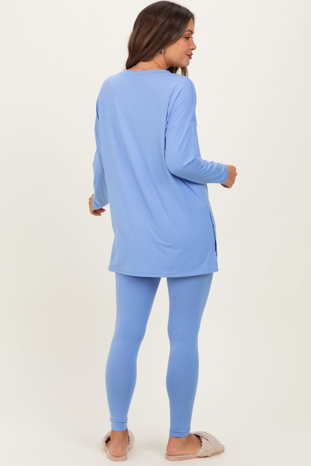 woman wearing a light blue maternity tunic top and matching leggings, showing a relaxed fit from the back
