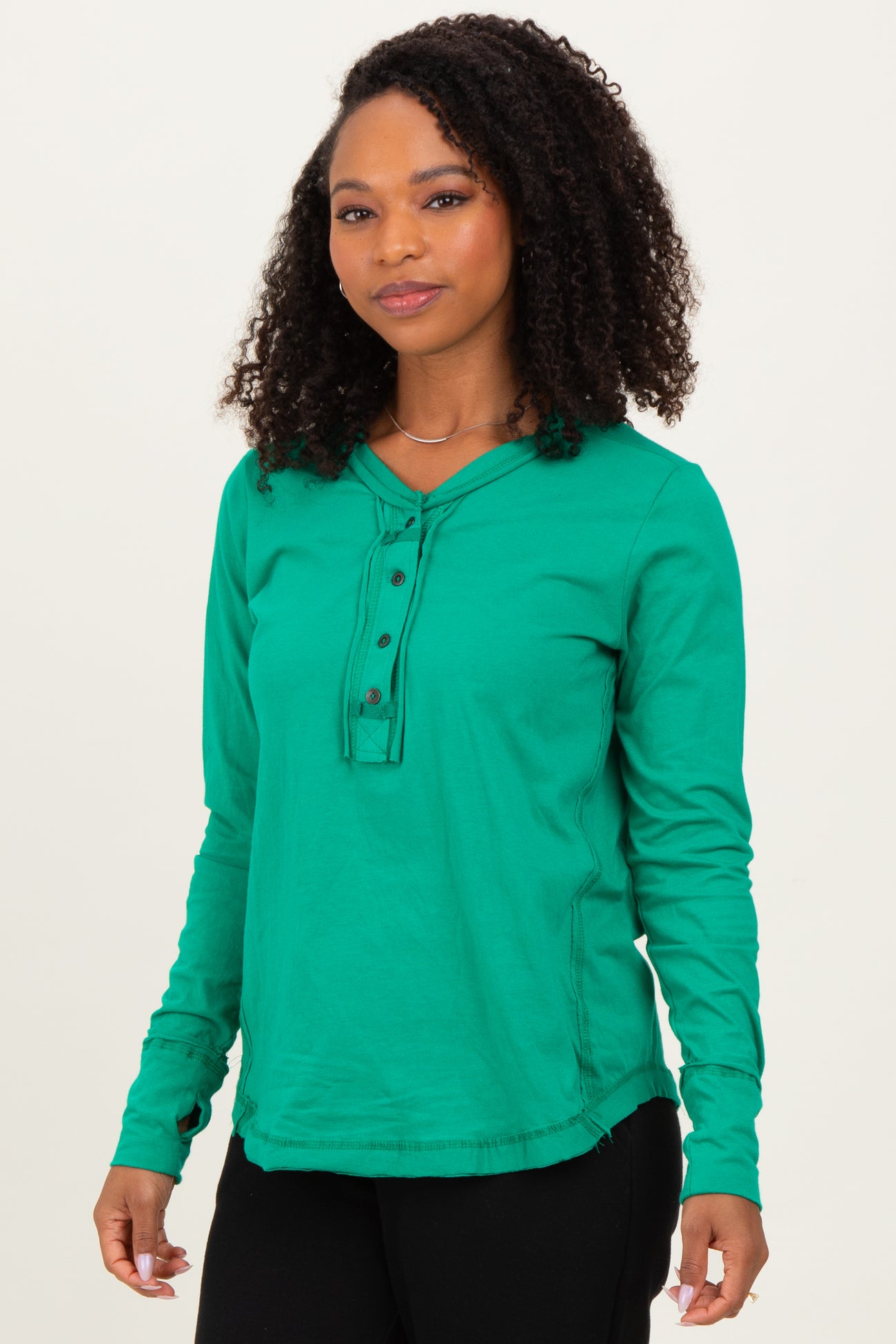 woman wearing a green long sleeve hoodie with button details and a relaxed fit
