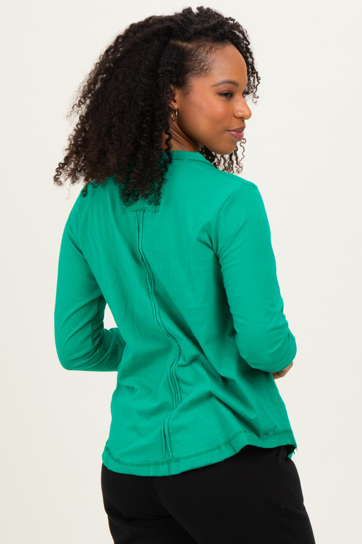 woman wearing a green long sleeve top with a back seam detail and a relaxed fit