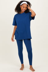 woman wearing a navy blue oversized t-shirt and matching leggings, standing barefoot with a headband in her hair
