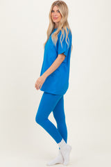 woman wearing a bright blue oversized t-shirt and matching leggings, styled with white ankle socks