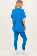 woman wearing a bright blue oversized t-shirt and matching blue leggings, with white ankle socks visible