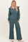 woman wearing a teal ribbed pullover with zip and matching wide-leg pants, styled with white sneakers