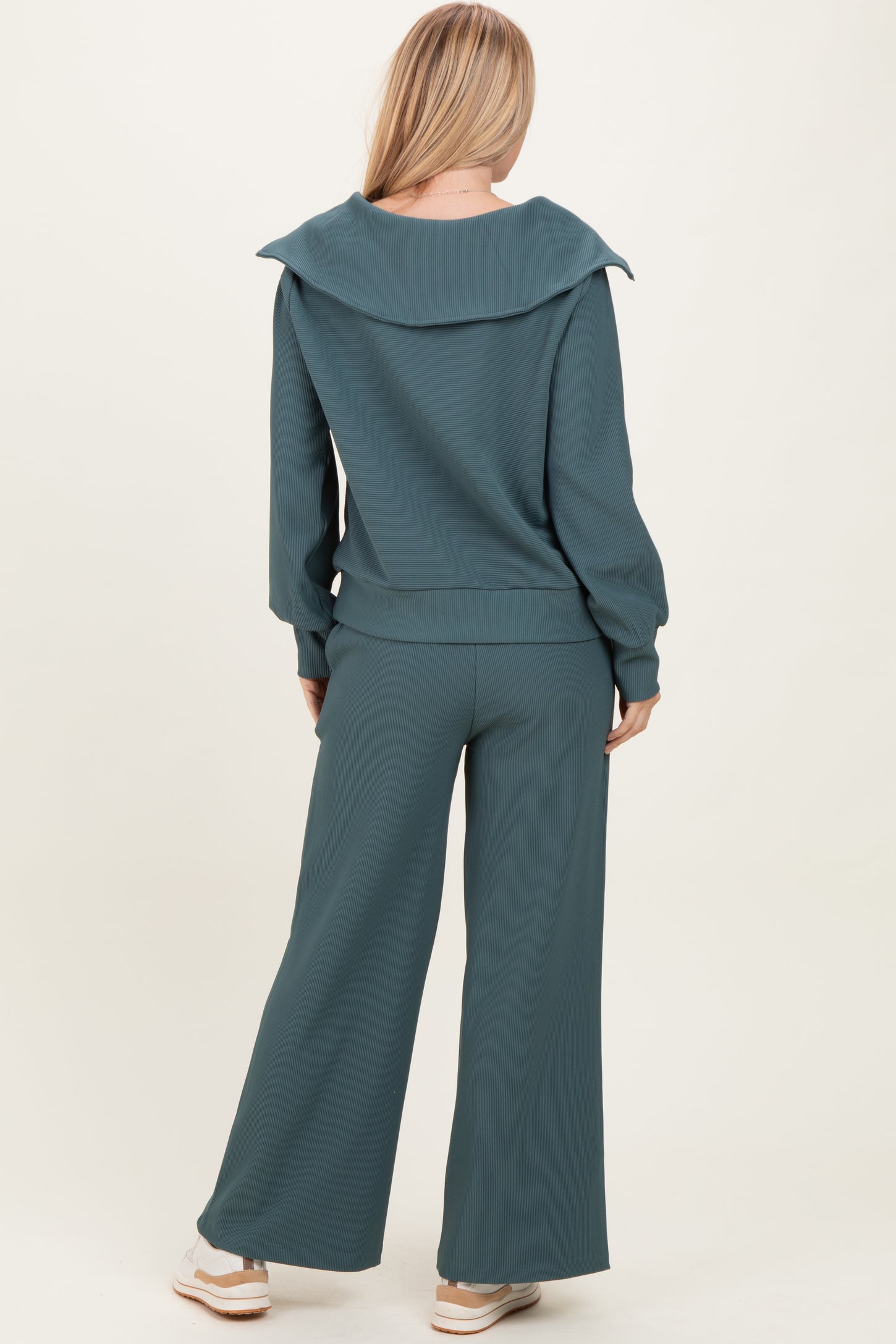 woman wearing a teal ribbed loungewear set with a wide collar and wide-leg pants, shown from the back