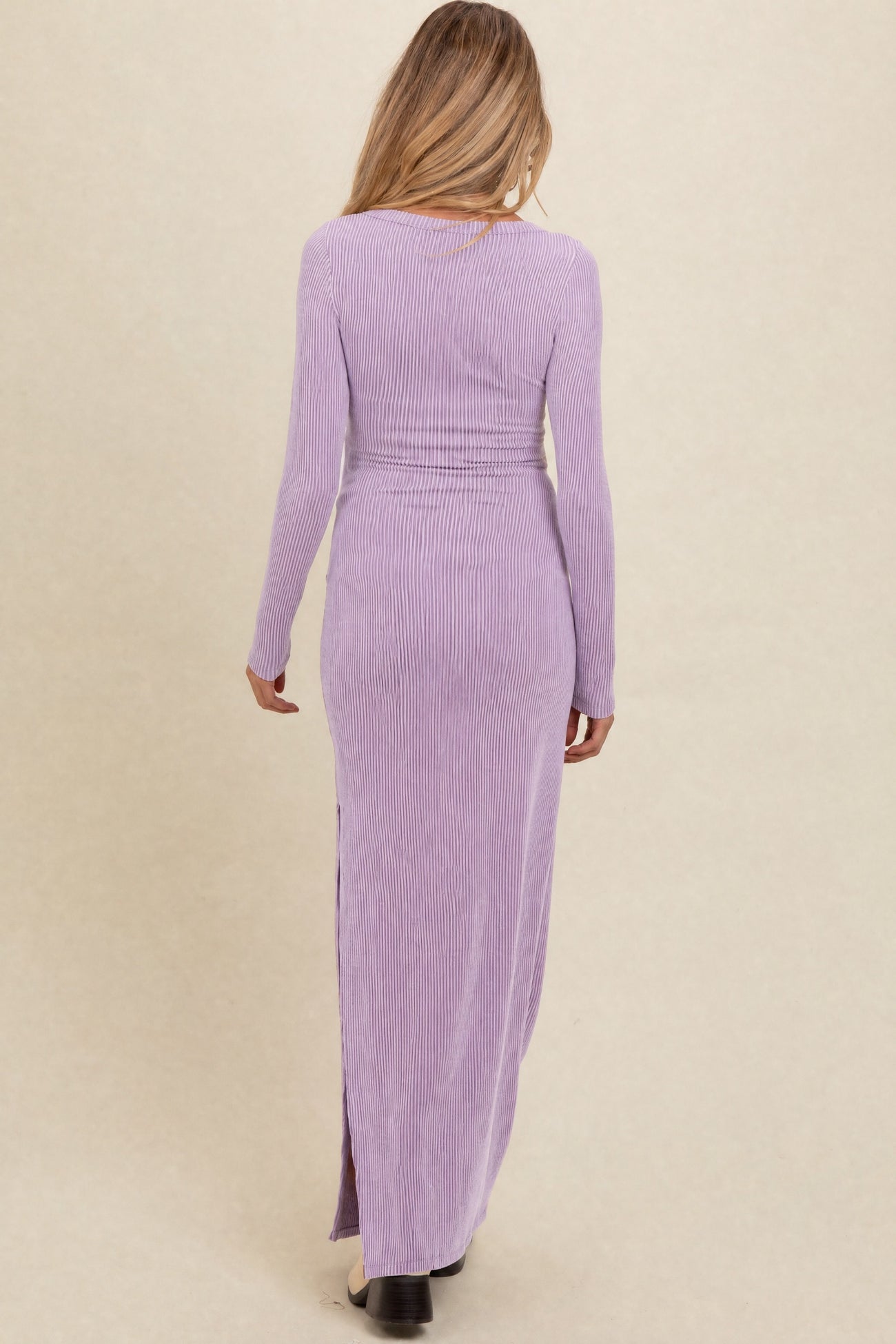 woman wearing a lavender long sleeve maternity maxi dress with a ribbed texture and side slit, showing a baby bump