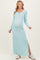 woman wearing a light blue ribbed long sleeve maternity dress with a side slit and showing her baby bump