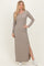 woman wearing a beige long sleeve ribbed maxi dress with side slits and white sneakers