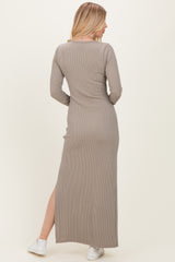 woman wearing a long taupe ribbed maxi dress with long sleeves and a side slit, viewed from the back