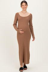woman wearing a brown ribbed maternity dress with long sleeves and holding her baby bump