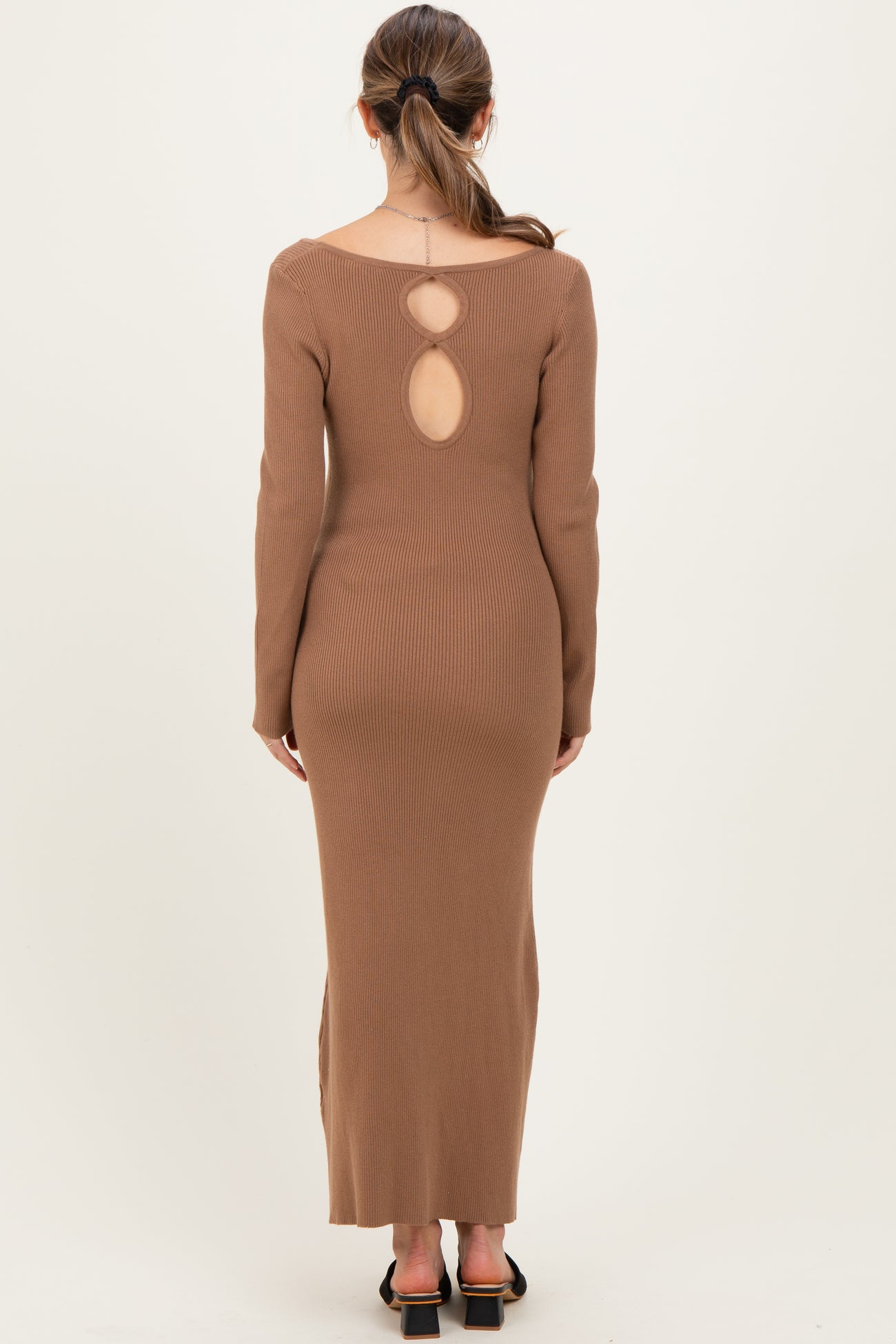 woman wearing a brown ribbed maternity dress with a keyhole back detail and long sleeves