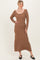 woman wearing a brown ribbed long sleeve midi dress with a scooped neckline and a fitted silhouette
