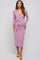 woman wearing a lavender long sleeve maternity dress with a tie waist and a visible baby bump