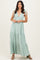 woman wearing a light green tiered maxi dress with tie straps and a v-neckline