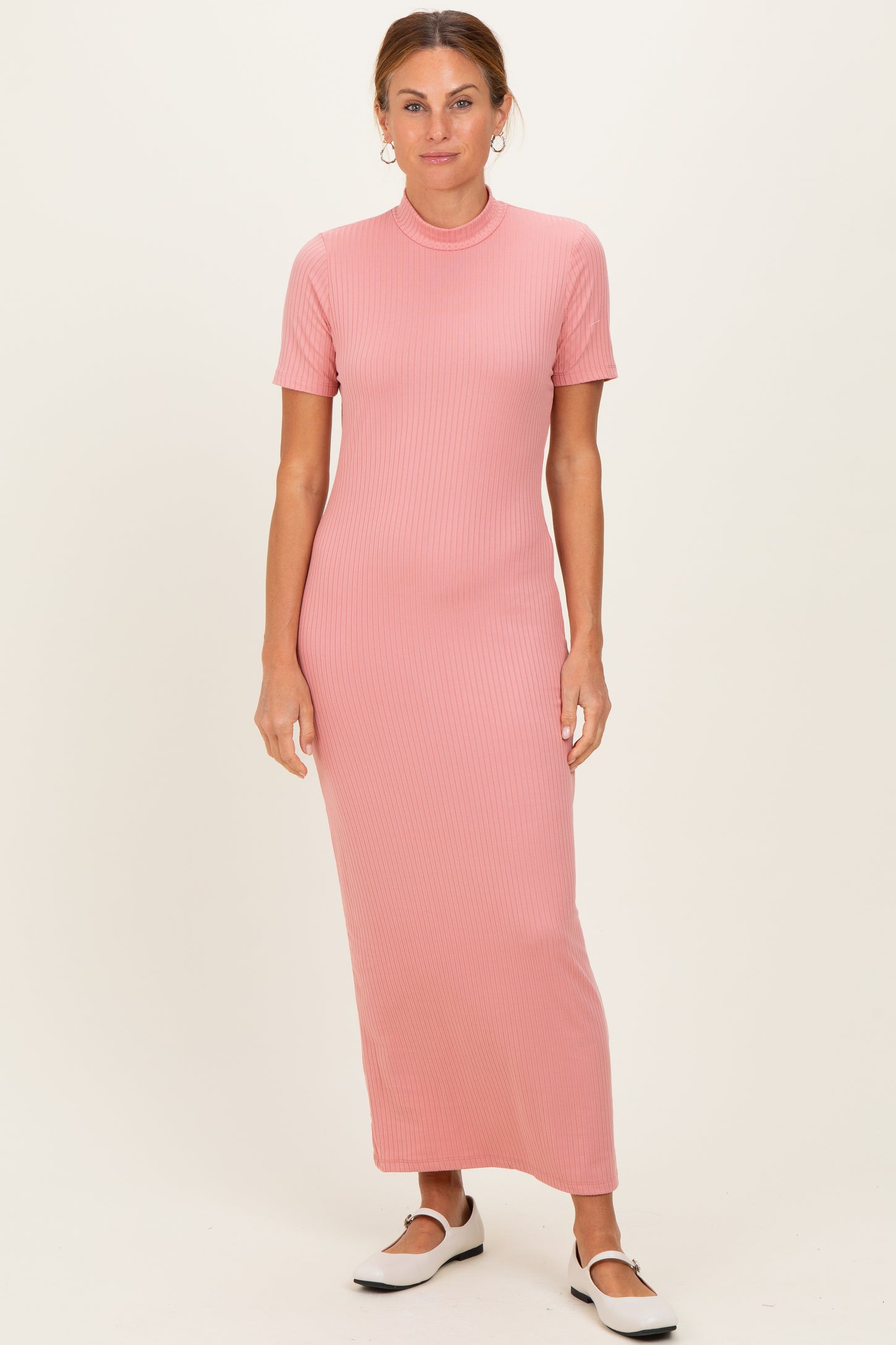 woman wearing a pink ribbed maxi dress with short sleeves and a fitted silhouette