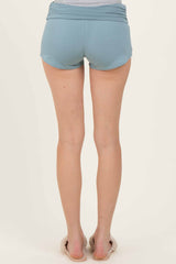 woman wearing light blue athletic shorts, seen from the back, with a relaxed fit and rolled waistband
