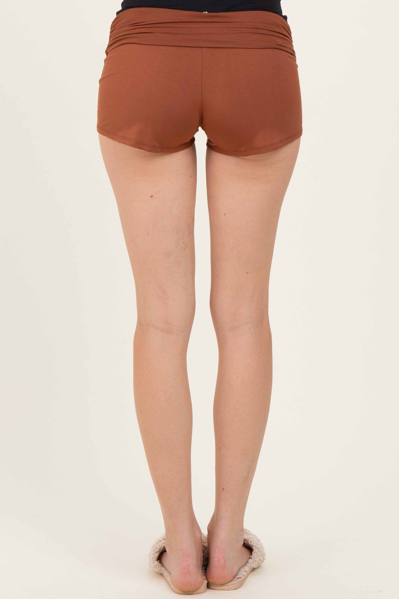woman wearing brown athletic shorts seen from the back with a smooth waistband and a comfortable fit