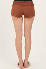 woman wearing brown athletic shorts seen from the back with a smooth waistband and a comfortable fit