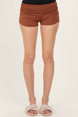 woman wearing brown high-waisted shorts with a fitted style and soft fabric, paired with cozy slippers