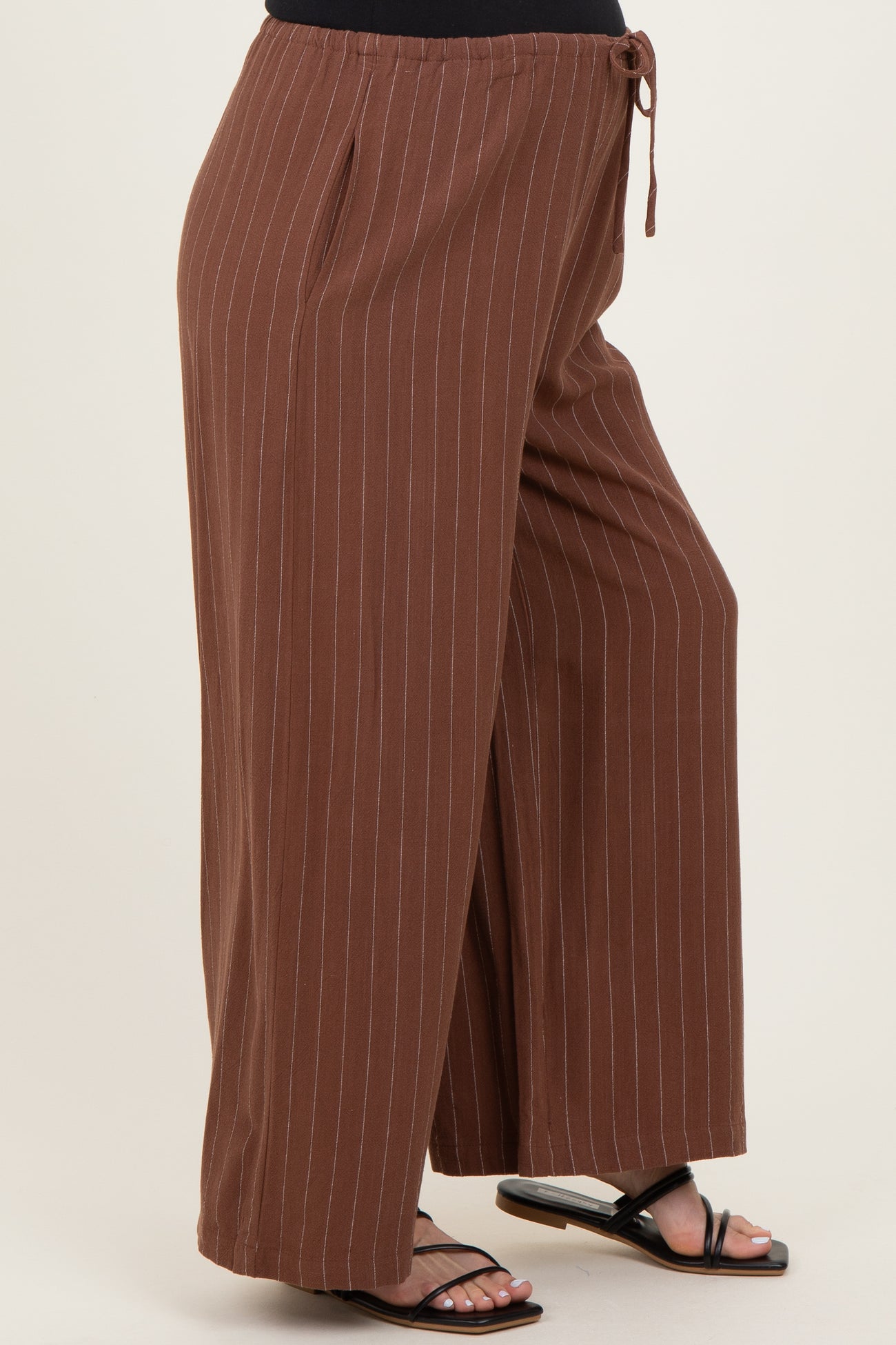 woman wearing brown striped maternity wide-leg pants with a drawstring waist and side slits