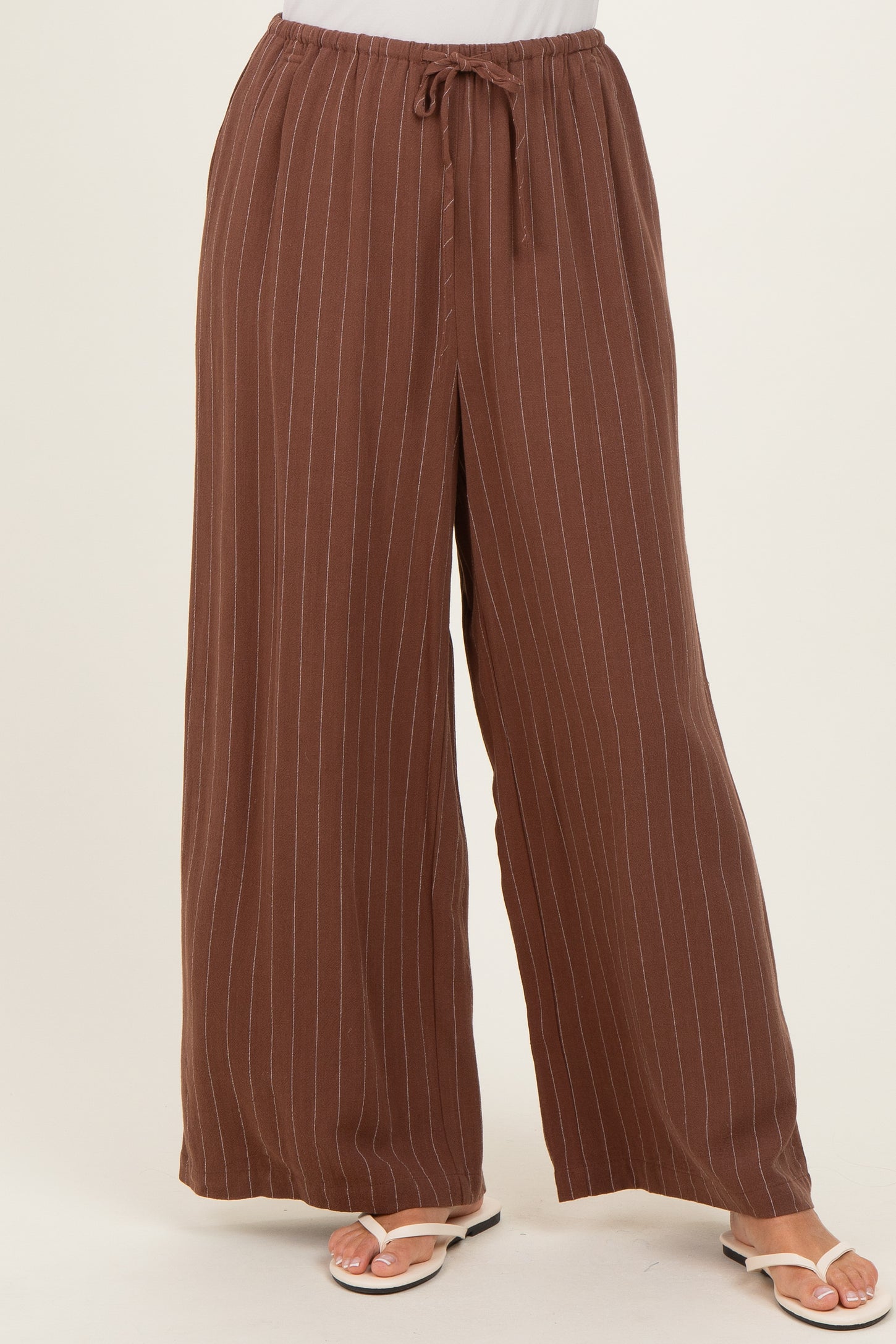 woman wearing brown striped wide-leg pants with an elastic waistband and drawstring detail
