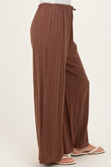 woman wearing brown pinstriped wide-leg pants with a drawstring waist and sandals