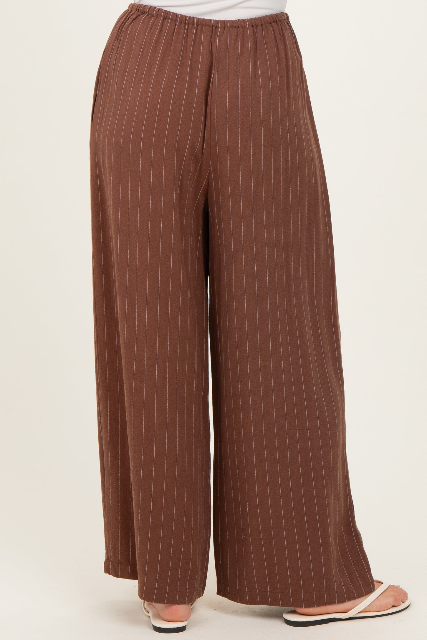 brown striped wide-leg pants with an elastic waistband and a relaxed fit, shown from the back