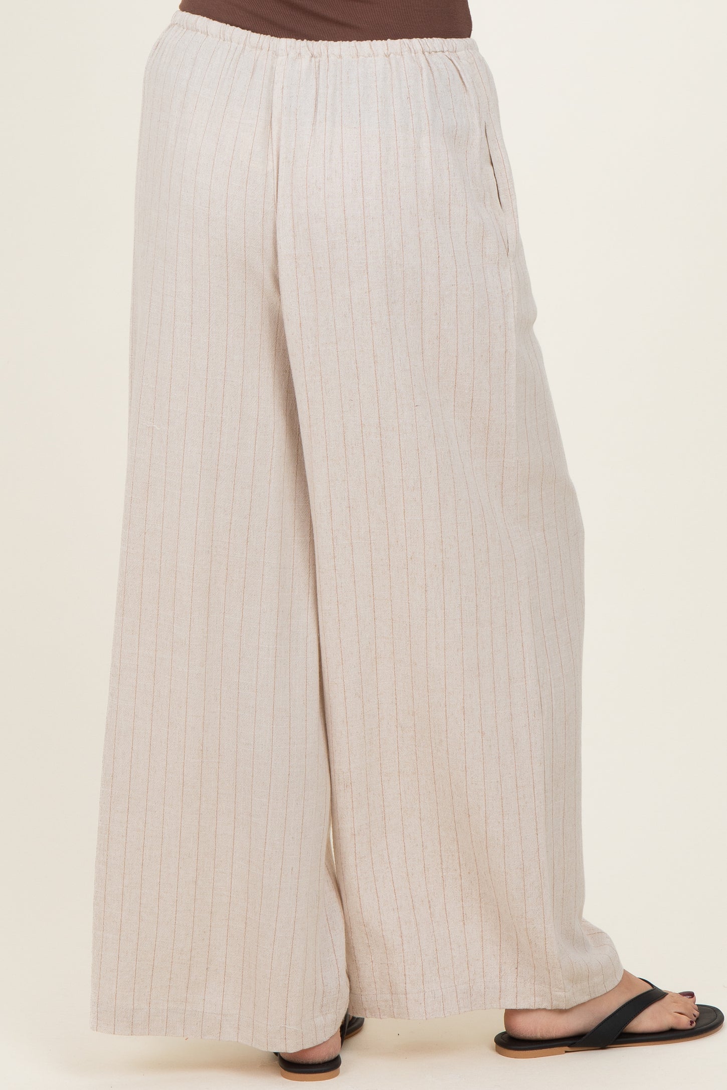 woman wearing light beige striped wide-leg pants with an elastic waistband and side pockets