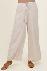 woman wearing light beige maternity wide-leg pants with pinstripes and a drawstring waist