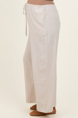 woman wearing light beige striped maternity pants with a drawstring waist
