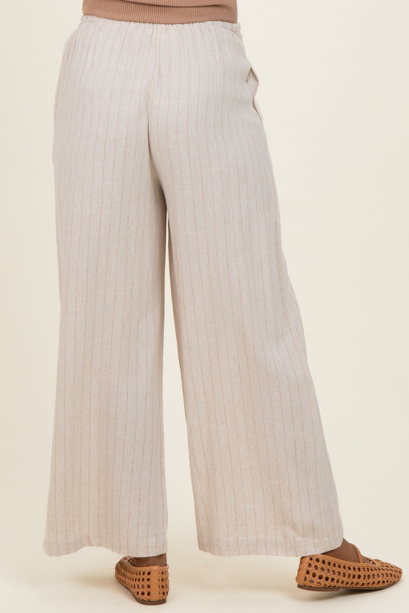 woman wearing light beige striped maternity wide-leg pants with a relaxed fit