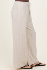 woman wearing light beige striped wide-leg pants with drawstring waist and side pockets