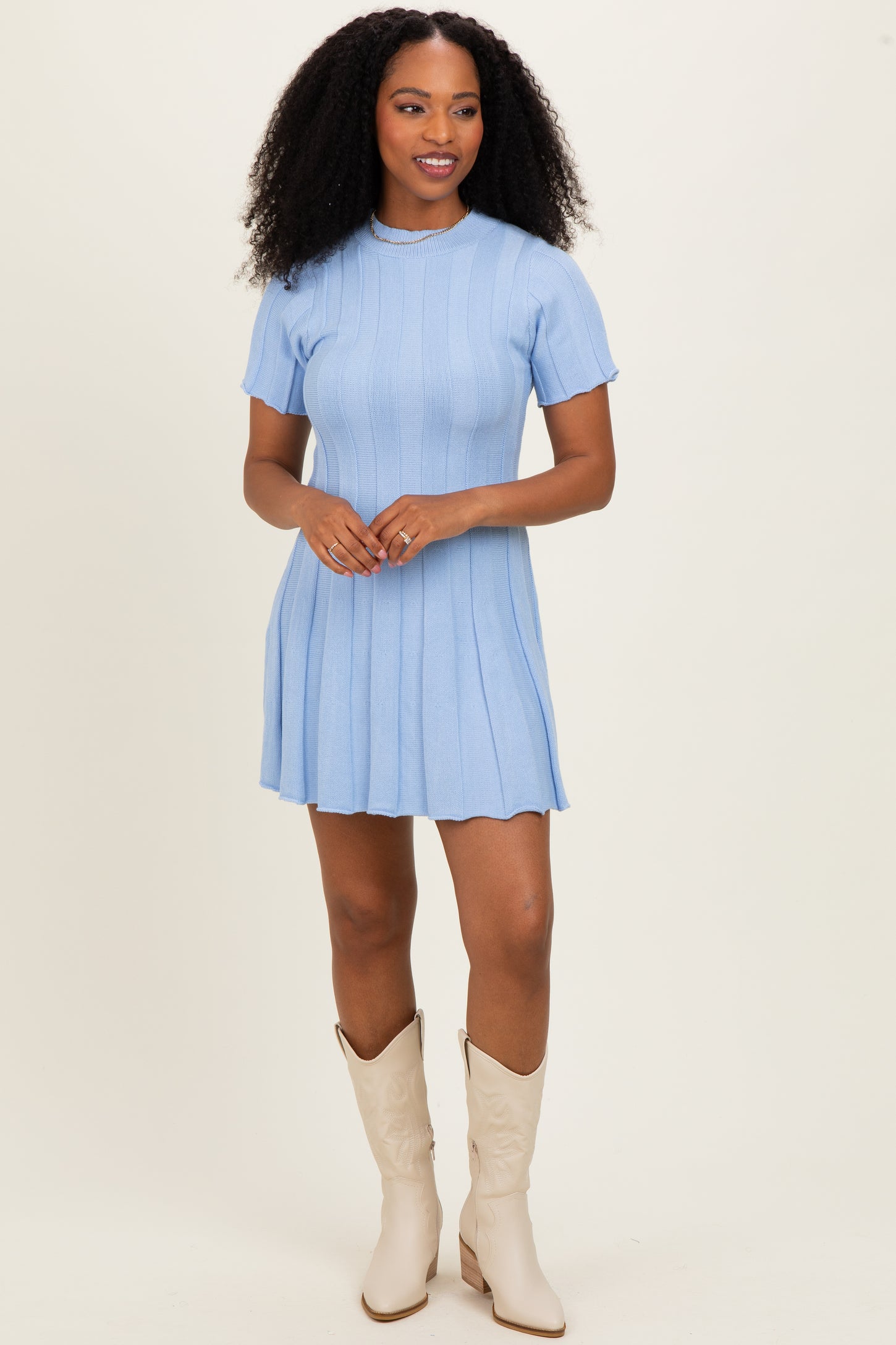 woman wearing a light blue short sleeve ribbed dress and cream cowboy boots