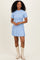 woman wearing a light blue short sleeve ribbed dress and cream cowboy boots