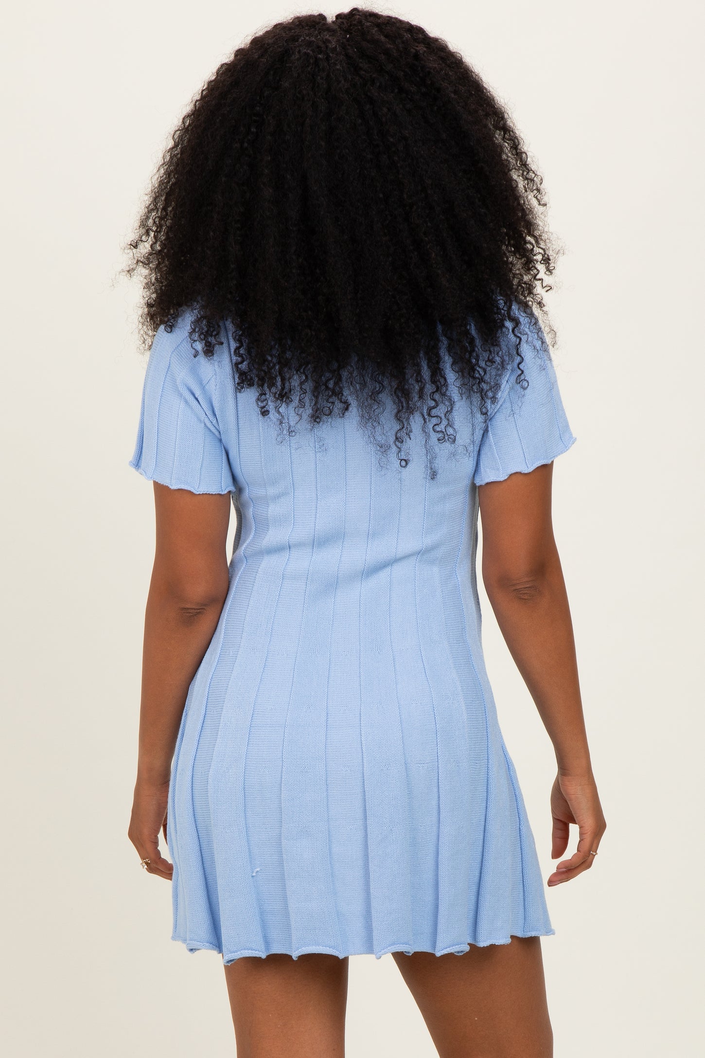 woman wearing a light blue ribbed knit short sleeve dress with a slightly flared hem and back view visible