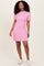 woman wearing a pink short sleeve ribbed knit dress with a flared skirt and white sneakers