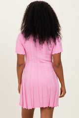 woman wearing a pink ribbed short sleeve dress with a fitted silhouette