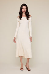 woman wearing a creamy off-the-shoulder ribbed midi dress with long sleeves and a fitted silhouette
