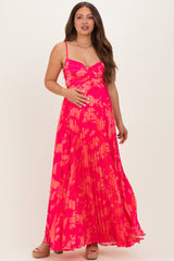 woman wearing a vibrant pink floral maternity maxi dress, showing her baby bump