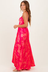 woman wearing a bright pink floral maxi dress with a pleated design and spaghetti straps