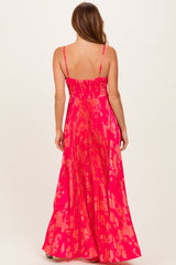 woman wearing a vibrant pink floral maxi dress with a smocked back and flowing pleated skirt
