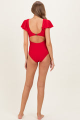 woman wearing a red maternity swimsuit with ruffled sleeves and an open back design