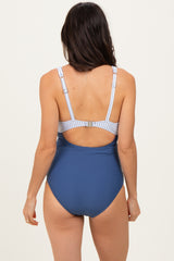woman wearing a blue one-piece swimsuit with a patterned back and adjustable straps