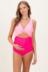woman wearing a pink maternity swimsuit with a knotted front and a fitted bottom, highlighting her baby bump