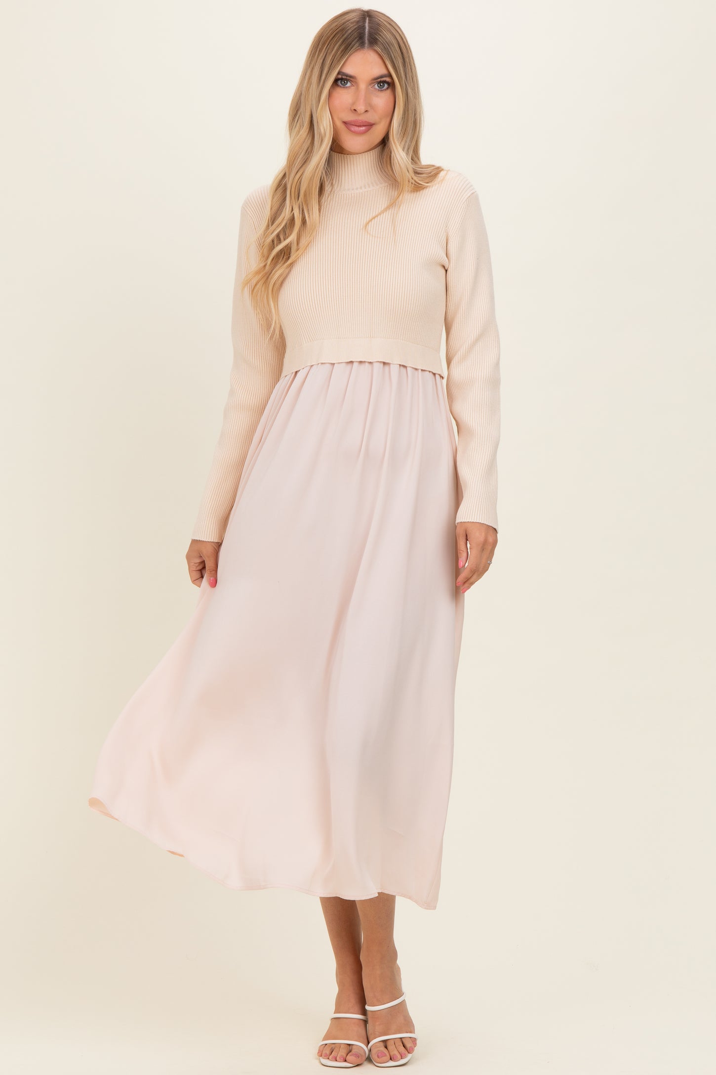 woman wearing a cream ribbed long sleeve top with a flowing blush maxi skirt