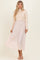 woman wearing a cream ribbed long sleeve top with a flowing blush maxi skirt
