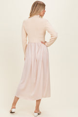 woman wearing a cream ribbed long sleeve top with a flowy blush pink midi skirt