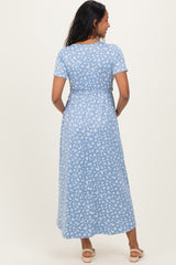 woman wearing a blue floral print maternity maxi dress, showing a baby bump from the back