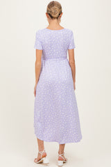 woman wearing a lavender floral maternity maxi dress with short sleeves and a cinched waist, showing her baby bump