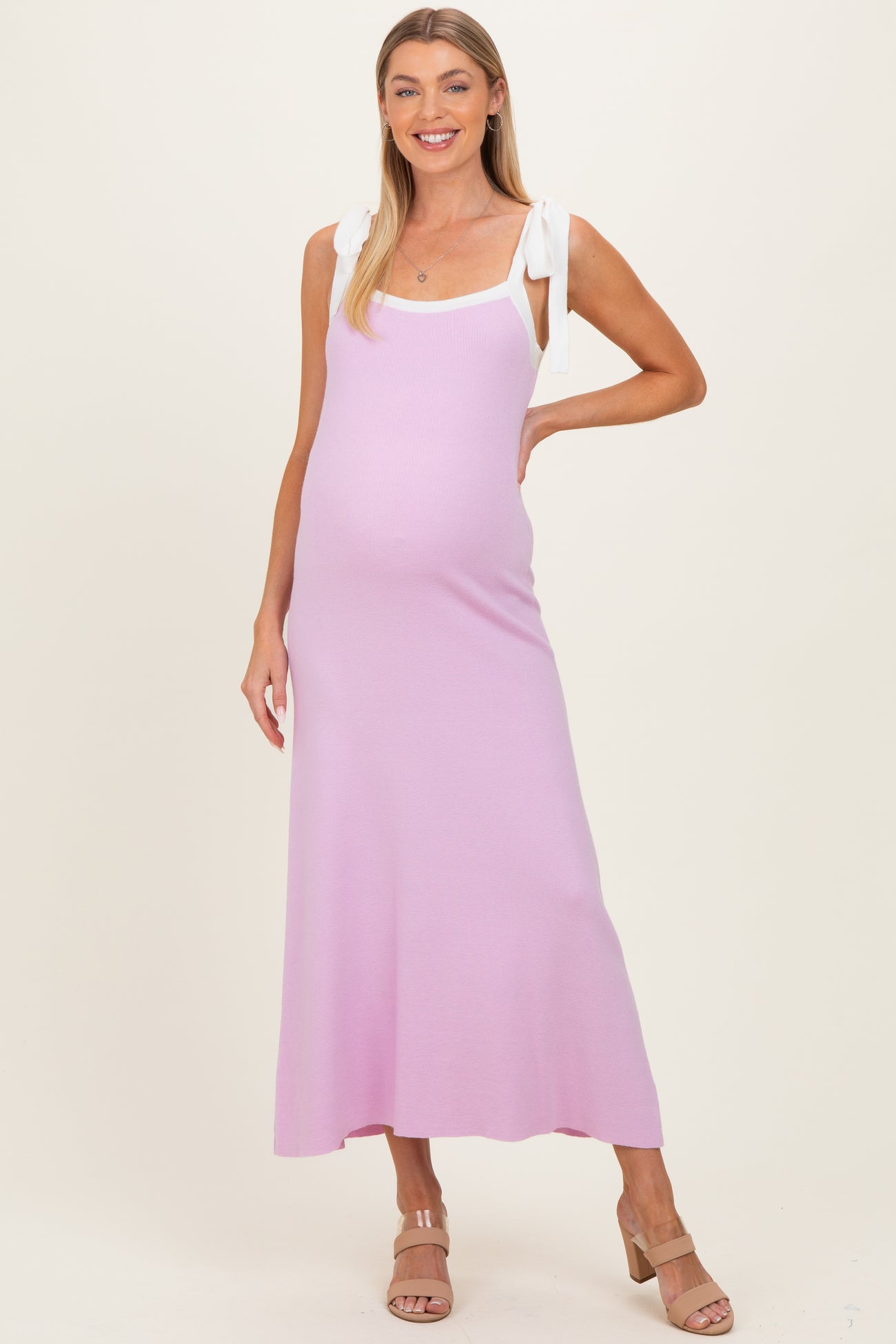woman wearing a light purple maternity maxi dress with tie straps and a visible baby bump