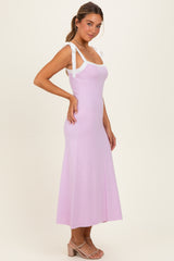 woman wearing a light purple maxi dress with white tie straps and a fitted bodice, posing sideways